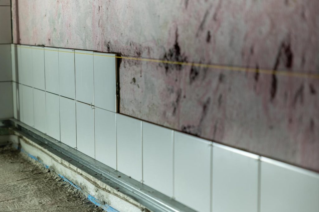 unfinished-wall-tiling-in-construction-site-29181495 Close-up of partially tiled wall in a construction area, showcasing incomplete renovation work.